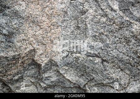 Untreated natural texture of gray granite close-up. Abstract background, texture, pattern, wallpaper. Stock Photo