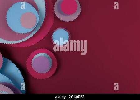 Abstract colored paper circles shapes in red background. Minimalist background. Flat lay. Copy space. Stock Photo