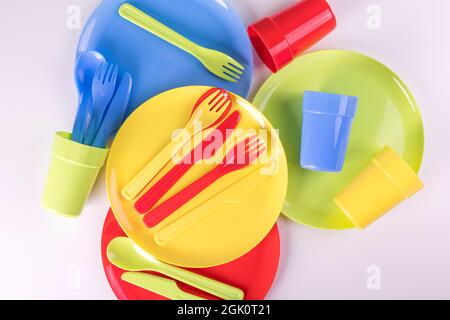 Bright colorful plastic disposable tableware isolated on white background. Flat lay. Stock Photo