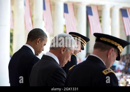 President Barack Obama, Defense Secretary Chuck Hagel and General Martin Dempsey, Chairman of the Joint Chiefs of Staff, bow their heads as Chaplain Col. Michael Brainerd delivers the invocation during a Memorial Day ceremony at the Arlington National Cemetery Memorial Amphitheater in Arlington, Va., May 26, 2014. (Official White House Photo by Pete Souza) This official White House photograph is being made available only for publication by news organizations and/or for personal use printing by the subject(s) of the photograph. The photograph may not be manipulated in any way and may not be use Stock Photo