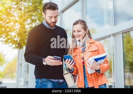 Two students with books on college or university campus Stock Photo
