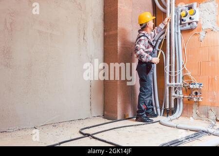 Senior male technician measuring the pipe with ruler Stock Photo