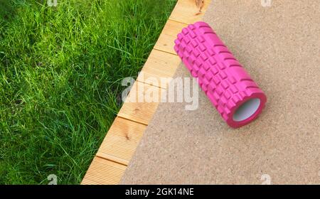 Home training equipment on home yard terrace. Fitness at home. Healthy, training and lifestyle concept. COPY-SPACE, banner. Pink Foam Roller Gym. Stock Photo