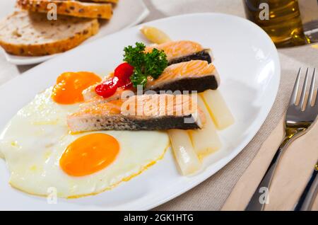 Fried salmon with scrambled eggs and asparagus Stock Photo