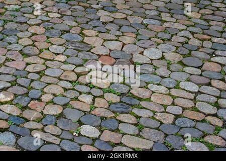 Close-up texture background view of a vintage cobblestone surface on a European city sidewalk and courtyard Stock Photo