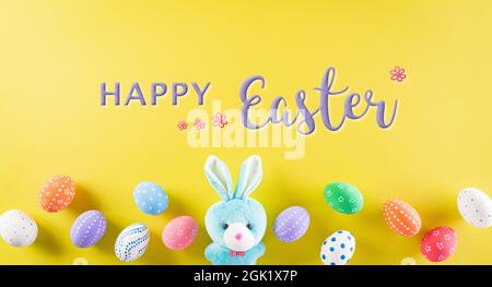 Happy easter! Colourful of Easter eggs on pastel yellow background with the text. Greetings and presents for Easter Day celebrate time. Stock Photo