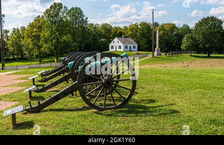 Civil war cannons lined up on the Antietam National Battlefield with the Dunker Church in the background in Sharpsburg, Maryland, USA Stock Photo