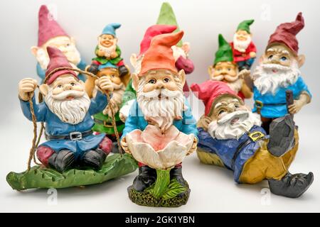 Group of well used garden gnomes on a neutral background. Stock Photo