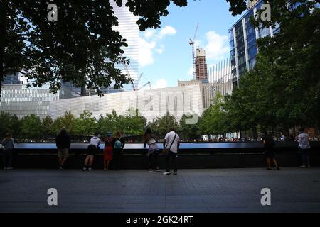 Visitors gather to pay tribute to the victims of 9/11 attacks near one of two reflecting pools at the National September 11 Memorial & Museum. Stock Photo