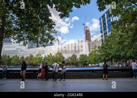 Visitors gather to pay tribute to the victims of 9/11 attacks near one of two reflecting pools at the National September 11 Memorial & Museum. Stock Photo