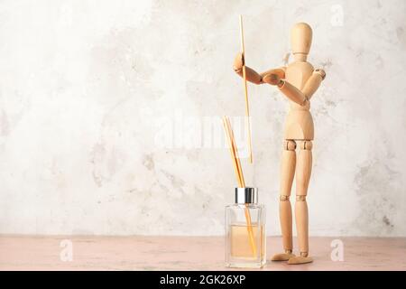Wooden mannequin with aroma diffuser on light background Stock Photo