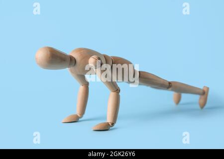 Wooden mannequin training on color background. Concept of sport Stock Photo