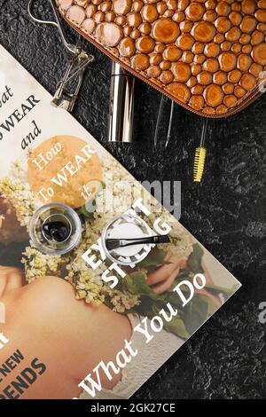 Cosmetic bag, henna, tools for eyebrows and eyelashes correction on dark background, closeup Stock Photo