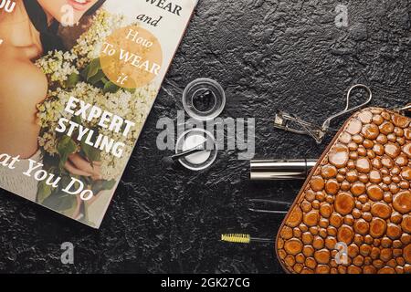 Cosmetic bag, henna, tools for eyebrows and eyelashes correction on dark background Stock Photo
