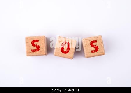SOS. Wooden blocks with an inscription on a white background. Stock Photo