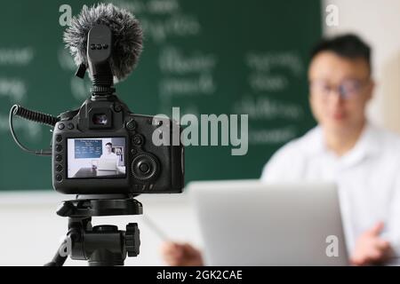 Asian teacher conducting English lesson online Stock Photo