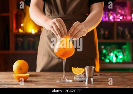 Woman preparing tasty aperol spritz cocktail at table Stock Photo