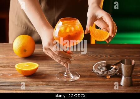 Woman preparing tasty aperol spritz cocktail at table Stock Photo
