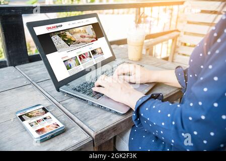 Online Shopping Website Article Blog  on laptop and smartphone. Woman Social Blogger optimizing online website template laptop working on responsive w Stock Photo