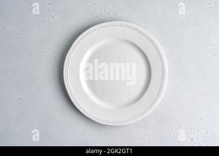 Empty white ceramic plate on light background. Copy space, top view, horizontal, closeup Stock Photo