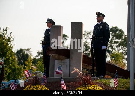 BLOOMINGTON, INDIANA - SEPTEMBER 11:  Members of the Bloomington Police Department stand next to a September 11th memorial during the 20th anniversary of the September 11th attack remembrance ceremony on SEPTEMBER 11, 2021 at Ivy Tech in Bloomington, Indiana. Twenty years ago terrorists attacked the United States on September 11, 2001 killing over 2000 people at the World Trade Center in New York, New York, and beginning a war with the United States that continues. Stock Photo
