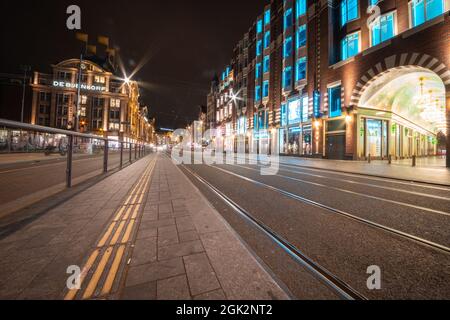 Amsterdam-Netherlands - August 21 2017; Retail street in city at night illuminated by building and traffic lights with department and clothing stores Stock Photo