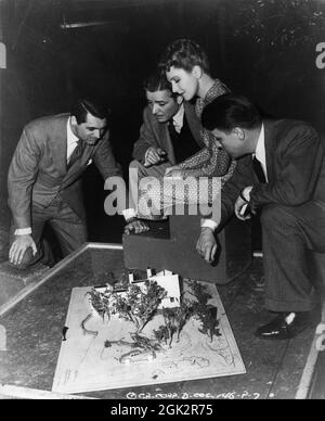 CARY GRANT RONALD COLMAN JEAN ARTHUR and Director GEORGE STEVENS study a Set Model on set candid during filming of THE TALK OF THE TOWN 1942 director GEORGE STEVENS story Sidney Harmon adaptation Dale Van Every screenplay Irwin Shaw and Sidney Buchman music Frederick Hollander Columbia Pictures Stock Photo