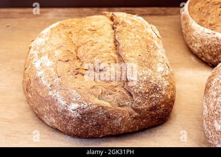 Close-up of loaf of brown homemade bread, brown dark bread with grains on the shop shelf Stock Photo