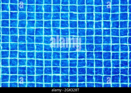Swimming pool surface texture close up top view, blue water background, caustics ripple, swimming pool tiled bottom backdrop, sea beach summer holiday Stock Photo