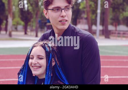 Young adults against the running track in a sports stadium. A ma Stock Photo