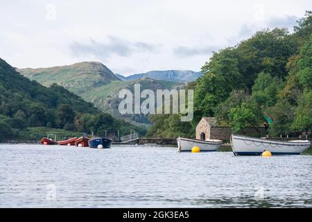 Moored boats on Ullswater with Helvellyn and mountains behind, Lake District, Cumbria, UK Stock Photo