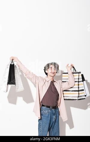 Portrait of happy young customer happy with his purchases standing against the white background Stock Photo