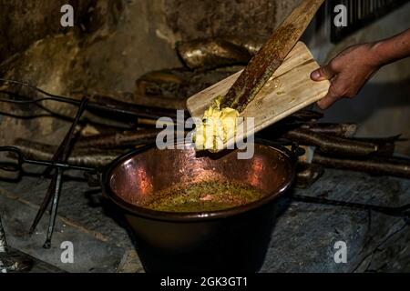 In Cerentino, visitors can stay in the lavishly renovated historic patrician house Cà Vegia, with centuries-old original furnishings but without electricity. Polenta is prepared over the open fire, Circolo della Rovana, Switzerland Stock Photo