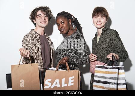 Portrait of young multiethnic people with shopping bags smiling at camera isolated on white background Stock Photo