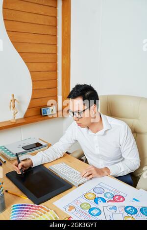 UI designer using graphic tablet when when drawing set of icons for new mobile application Stock Photo