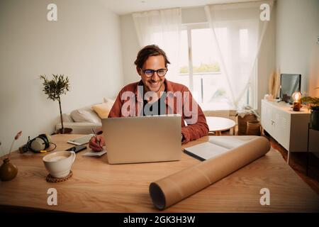 Caucasian male student working from home typing on laptop finishing project  Stock Photo