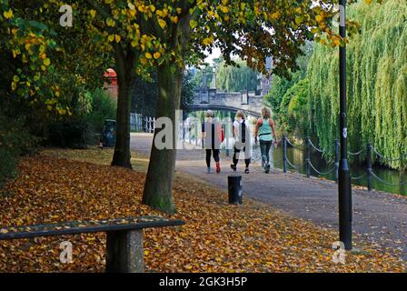 A view of three ladies walking on the riverside path by the River Wensum near Whitefriars Bridge in the City of Norwich, Norfolk, England, UK. Stock Photo