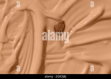 Abstract cosmetic textured background, nail polish drop on beige liquid foundation texture. Moisturizing beauty creme, balm swatch, pink paint, yogurt Stock Photo