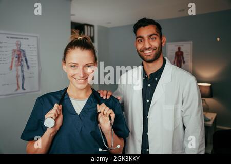 Caucasian female nurse standing with mixed race male surgeon Stock Photo