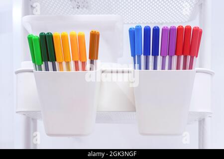 Multicolored felt-tip pens in white storage containers for school supplies. Stock Photo