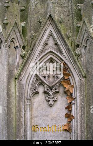 Vertical shot of a part of a weathered ornamental stone sculpture in a cemetery Stock Photo