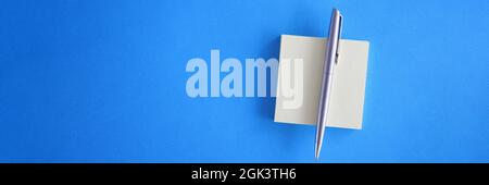 White sticky notes with pen on light blue background Stock Photo