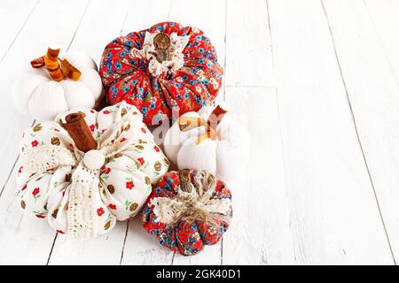 Cozy pumpkins. Autumn decoration with handmade colorful fabric pumpkins on white wooden background. Fall vibes. Thanksgiving decor. Stock Photo