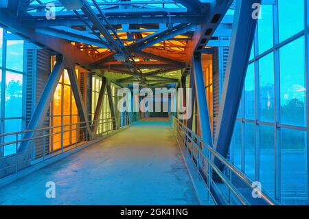 A futuristic pedestrian overpass over a motorway made from a glass steel overpass. Stock Photo