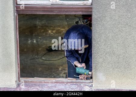 A worker works on the reconstruction of a window in the house Stock Photo