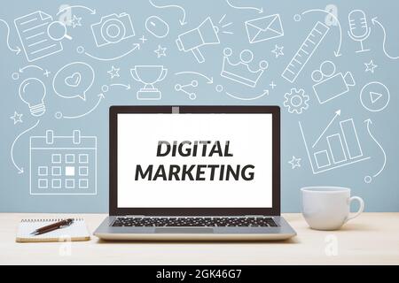 Digital marketing text on laptop screen with icon diagram background. Digital marketing concept on blue backdrop. Stock Photo