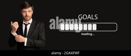 Handsome mature businessman in formal suit posing on black background, collage with GOALS loading progress bar Stock Photo
