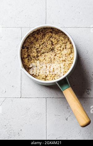 Cooked quinoa in saucepan, gray tile background, top view. Healthy food concept. Stock Photo