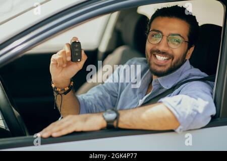 Cheerful middle-eastern long-haired guy showing car key Stock Photo