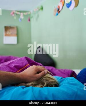 Berlin, Germany. 11th Sep, 2021. A father puts his hand on the head of a child lying in bed. Credit: Annette Riedl/dpa/Ģ����ý Live News Stock Photo